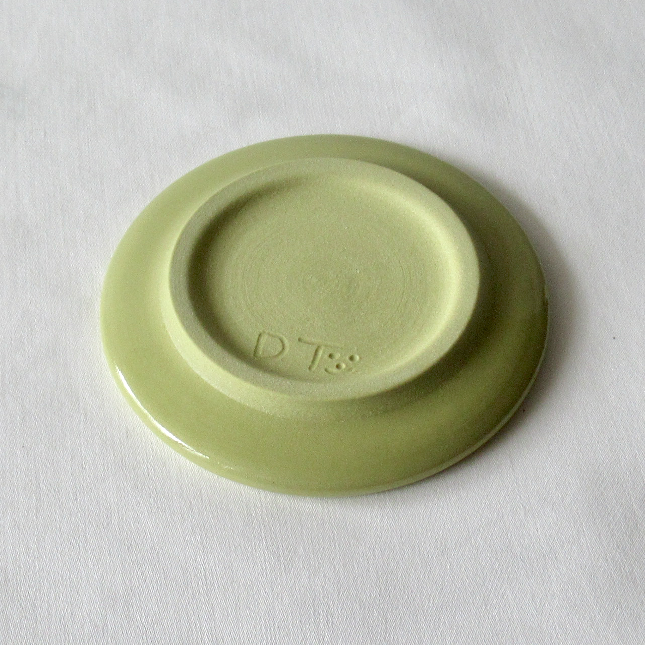 A Very Small Wheel-thrown Lime Green Porcelain Sand Dollar Sgraffito Plate