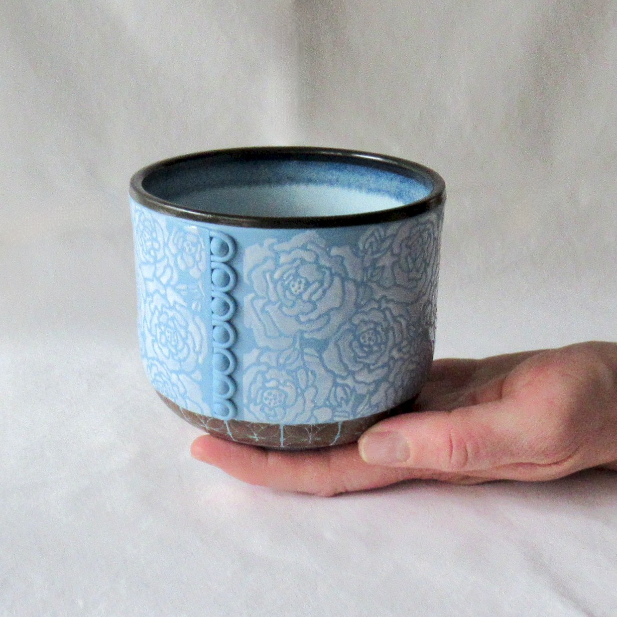 A Rouleau Loops, Buttons and White Roses on a Blue Porcelain Bowl