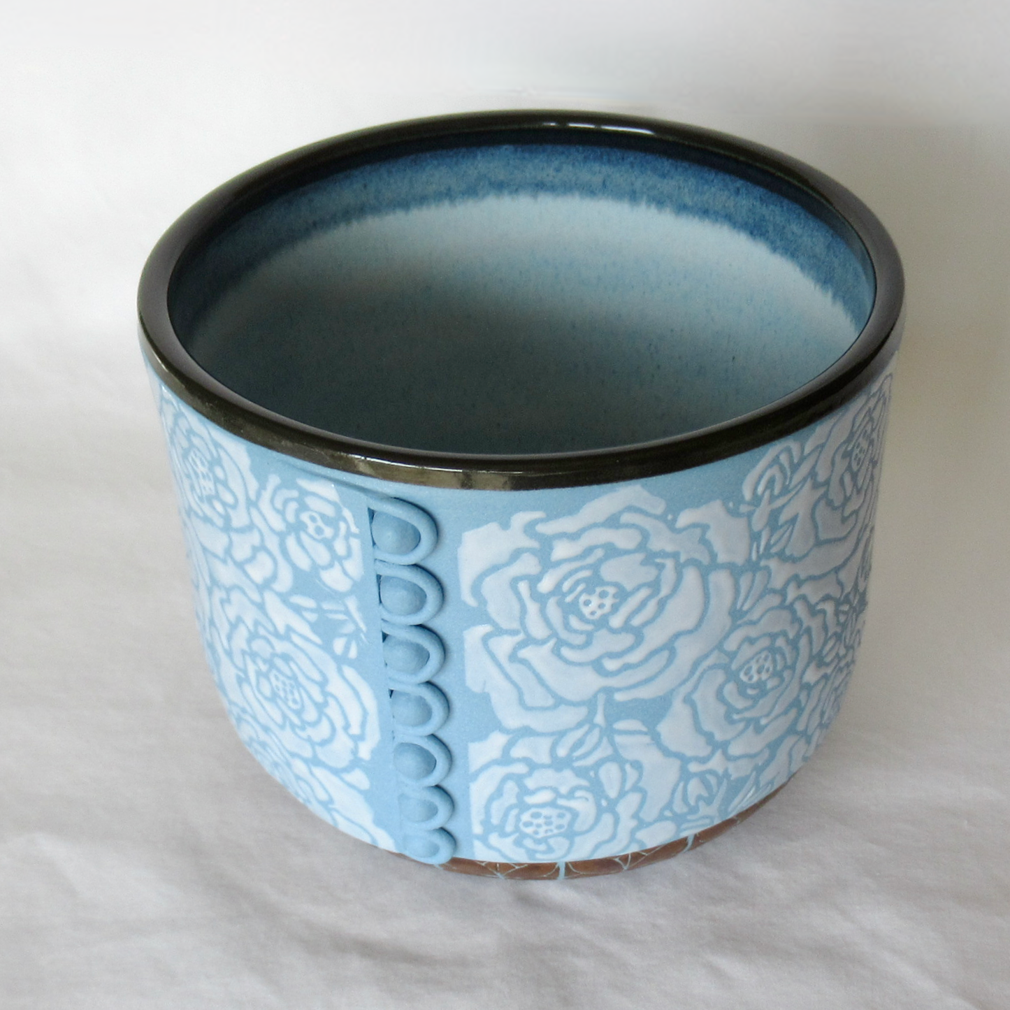A Rouleau Loops, Buttons and White Roses on a Blue Porcelain Bowl