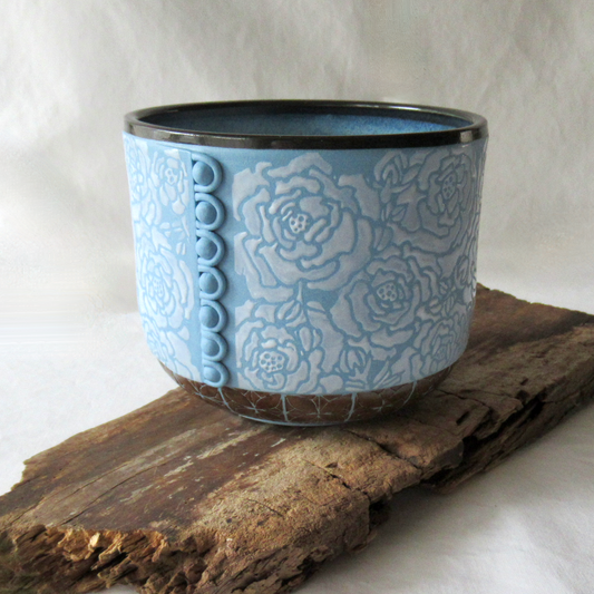 A Rouleau Loops, Buttons and White Roses on a Blue Porcelain Bowl