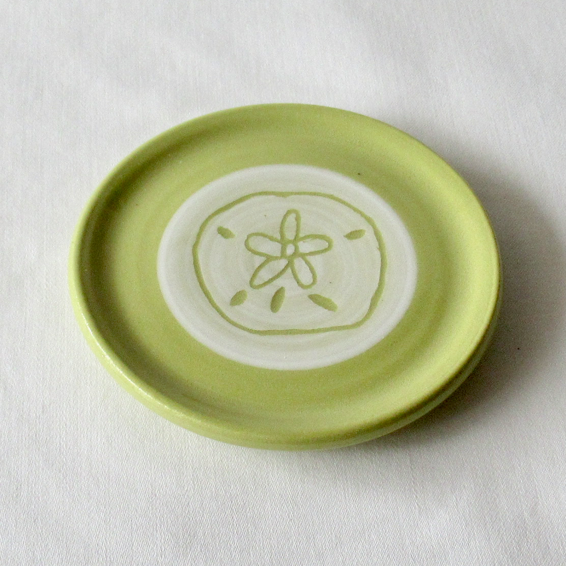 A Very Small Wheel-thrown Lime Green Porcelain Sand Dollar Sgraffito Plate