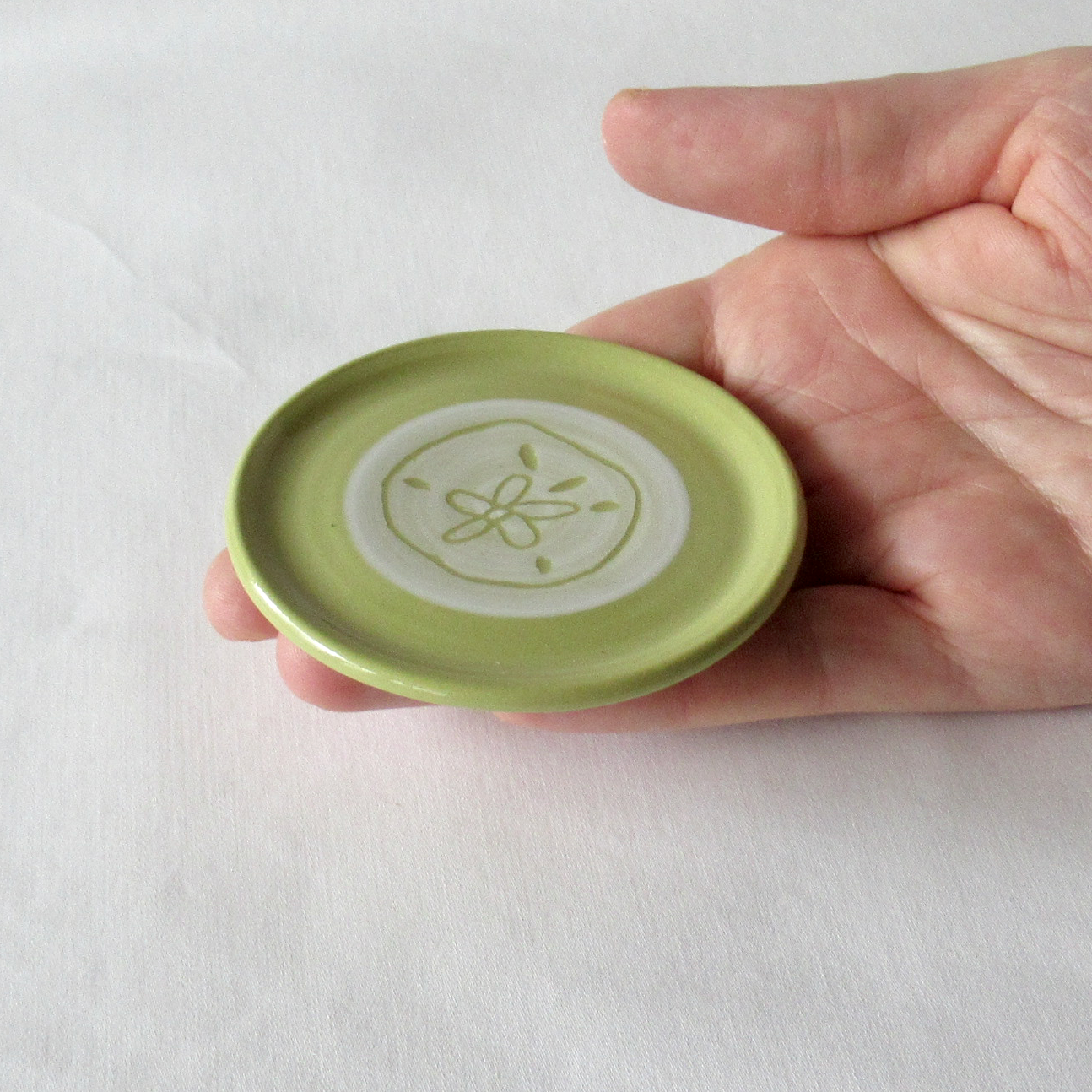 A Very Small Wheel-thrown Lime Green Porcelain Sand Dollar Sgraffito Plate
